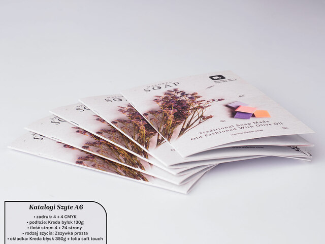 Mały katalog A6 z żywą grafiką na okładce, prezentowany na stole